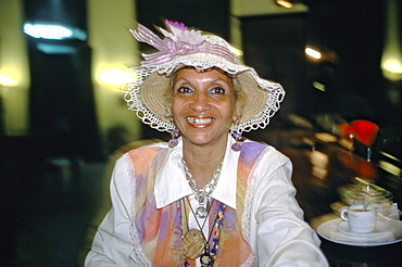 A Cuban woman having a cup of coffee in a bar in Habana Vieja, Havana, Cuba