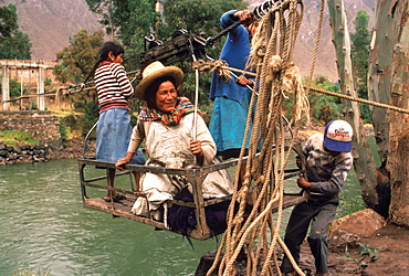 Small cable car holding passengers suspended over the Urubamba River near Cuzco useful technology where there are no bridges, Andes Mountains, Highlands, Peru