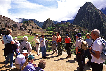 Machu Picchu tourist group with guide visiting the ancient city enormous numbers of tourists come to the site each year, Highlands, Peru