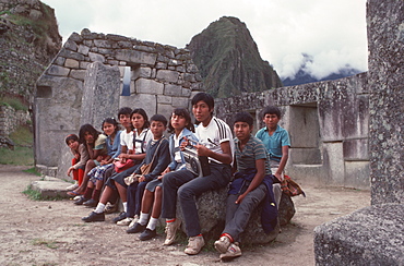 Machu Picchu The Temple of the Three Windows in the Sacred Area, and group of visiting Peruvian school children, Highlands, Peru