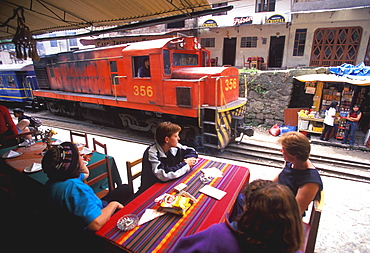 Machu Picchu the train from Cuzco arrives in Aguas Calientes the town and station below site train passes restaurants on main street, Highlands, Peru