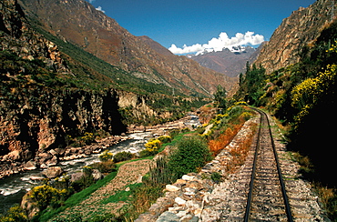 The train from Cuzco to Machu Picchu travels along the Urubamba River Valley with snow capped mountains above, Highlands, Peru