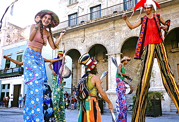 Street entertainers in costume and on stilts entertaining passersby in Habana Vieja, Havana, Cuba