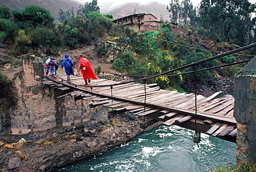 Hikers on the Inca Trail passing over the Urubamba River on a suspension bridge near Chilca on the way to Machu Picchu, Peru