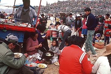 Inti Raymi spectators eating lunch during the Incan Festival of the Sun, held at Sacsayhuaman, above Cuzco on June 24th, Peru