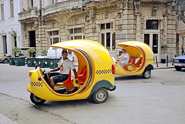 Tourist taxis called 'coco' taxi, powered by a small gasoline engine operating on a street in Havana, Cuba