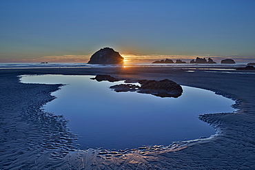 Sunset by a sea stack over a pool on the beach, Bandon Beach, Oregon, United States of America, North America 