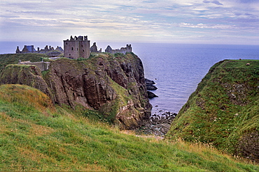 Dunnotar Castle dating from the 14th century, and piper playing, near Stonehaven, Aberdeenshire, Scotland, United Kingdom, Europe