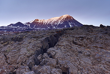 Deep crack in lava field near Lake Myvatn, Mount Hlidarfjall, 771m, in the distance, northern Iceland, Iceland, Polar Regions