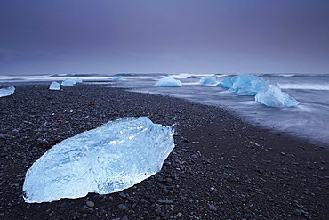 Iceberg washed ashore on Breidamerkursandur black sands, near Jokulsarlon glacial lagoon, East Iceland, Polar Regions