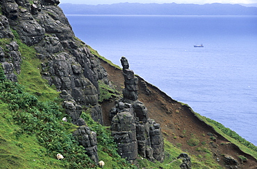 Rocky east coast of Trotternish and passing boat, Raasay in the background, Isle of Skye, Inner Hebrides, Scotland, United Kingdom, Europe