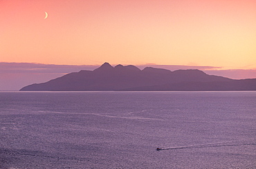 Fishing boat returning to Elgol, Rum island in the distance, at sunset, Isle of Skye, Inner Hebrides, Scotland, United Kingdom, Europe