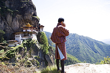 Bhutanese man with cell phone, Taktshang Goemba (Tiger's Nest) Monastery, Paro, Bhutan, Asia