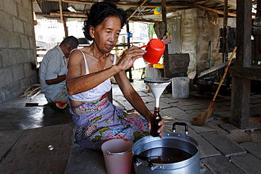 Bottling coconut oil to sell, Koh Samui, Thailand, Southeast Asia, Asia