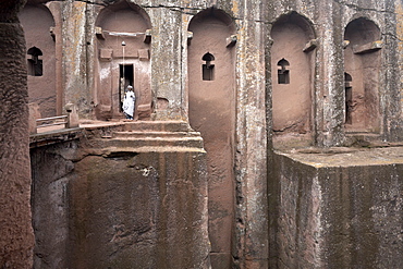 A priest stands at the entrance to the rock-hewn church of Bet Gabriel-Rufael, in Lalibela, UNESCO World Heritage Site, Ethiopia, Africa