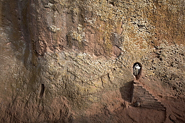 A woman emerges from a tunnel leading to the rock-hewn church of Bet Amanuel, in Lalibela, Ethiopia, Africa