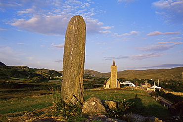 Standing stone and church, village of Glencolumbkille, County Donegal, Ulster, Republic of Ireland, Europe