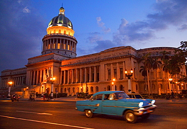 Traditional old American car speeding past the Capitolio building at night, Havana, Cuba, West Indies, Central America