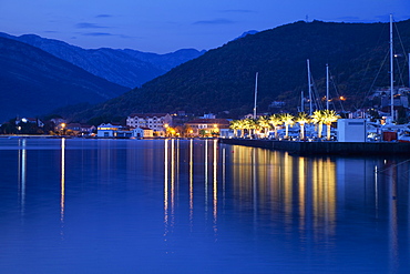 Waterfront at dusk at the newly developed Marina in Porto Montenegro with mountains behind, Montenegro, Europe