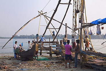 Fishermen preparing traditional boat and Chinese fishing net on the waterfront at Kochi (Cochin), Kerala, India, Asia 