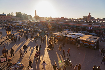 Evening light on the busy square of Place Jemaa el-Fna with the minaret of the Koutoubia Mosque in the distance, UNESCO World Heritage Site, Marrakech, Morocco, North Africa, Africa