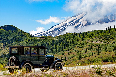 Beautifully restored Vintage American car passing Mount St. Helens, part of the Cascade Range, Pacific Northwest region, Washington States, United States of America, North America