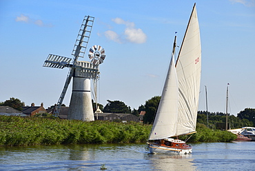 Sailing boat in front of Thurne Dyke Drainage Mill, windmill, Thurne, Norfolk, England, United Kingdom, Europe