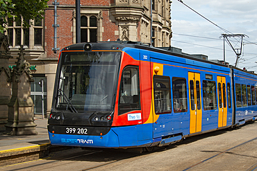 Sheffield tram known as 'Supertram' approaching a stop in Church Street, Cathedral Quarter,