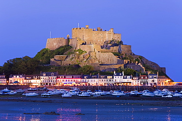 Mount Orgueil Castle, illuminated at dusk, overlooking Grouville Bay in Gorey, Jersey, Channel Islands, United Kingdom, Europe