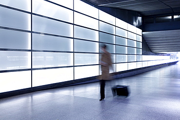 Person walking with motion blur in passageway at modern train station, Berlin, Germany, Europe