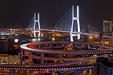 High angle wide shot traffic on Nanpu Bridge spiral and Bridge, illuminated at night, Shanghai, China, Asia