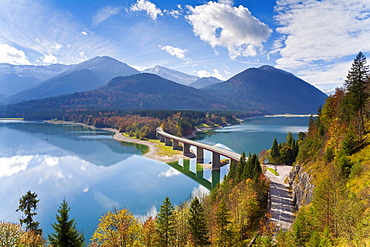 Reflections of a road bridge over Lake Sylvenstein, with mountains in the background, Bavaria, Germany, Europe