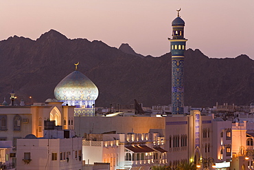 Elevated dusk view of buildings along the Corniche, latticed buildings and Mutrah Mosque, Muscat, Oman, Middle East