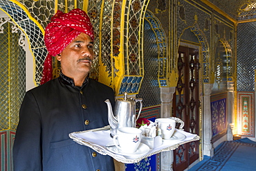 Waiter carrying tea tray in ornate passageway, Samode Palace, Jaipur, Rajasthan, India, Asia