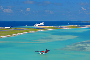 Passenger jet taking off from Male International Airport, and Maldivian air taxi ready to take off, Maldives, Indian Ocean, Asia