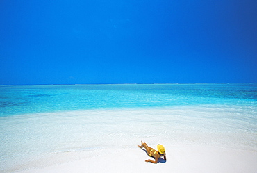 Woman reading a book on the beach, Maldives, Indian Ocean, Asia