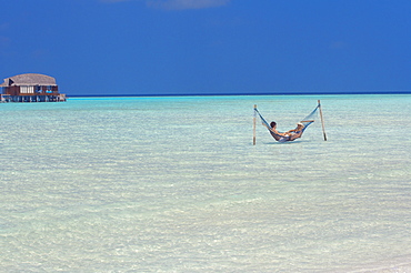 Couple relaxing in hammock, Maldives, Indian Ocean, Asia