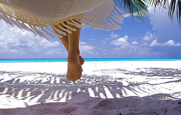 Woman sitting on a hammock overlooking sea, The Maldives, Indian Ocean, Asia