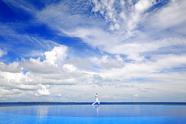 Young man meditating by infinity pool, Maldives, Indian Ocean, Asia