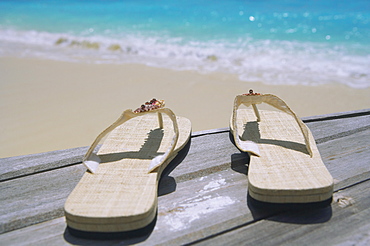 Pair of slippers on deck on beach 