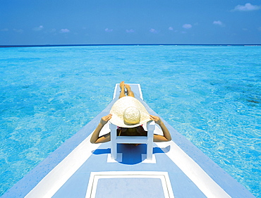 Woman relaxing on deck of boat, Maldives, Indian Ocean, Asia