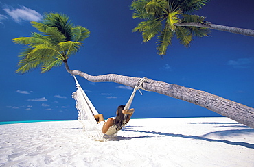 Woman in hammock on beach, Maldives, Indian Ocean, Asia