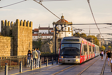 The Metro light rail line on the The Dom Luís I Bridge and the Walls of Dom Fernando or Fernandine Walls, Douro River, Porto, Portugal.