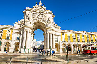 Tram passing the Arco da Rua Augusta or Triumphal Arch of Praca do Comercio, Lisbon, Portugal.