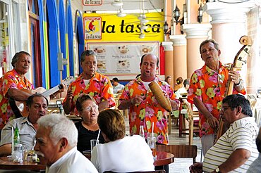 Mexico, Veracruz, Marimba band playing in the Zocalo for people seated at cafe tables.