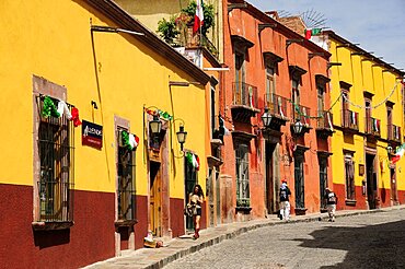 Mexico, Bajio, San Miguel de Allende, Independence Day decorations adorn colonial streets lined by brightly painted buildings.