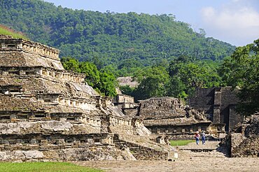 Mexico, Veracruz, Papantla, El Tajin archaeological site View of Tajin Viejo site with hills behind tourist couple in middle foreground.