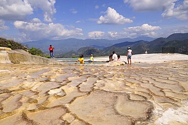 Mexico, Oaxaca,  Hierve el Agua, Tourists beside limestone pool.