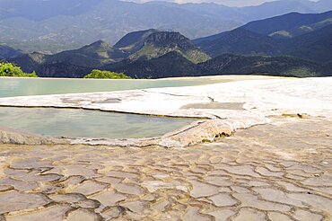 Mexico, Oaxaca,  Hierve el Agua, Mountainous landscape with limestone pools in the foreground.