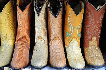 Mexico, Jalisco, Guadalajara, Line of embroidered leather boots for sale.